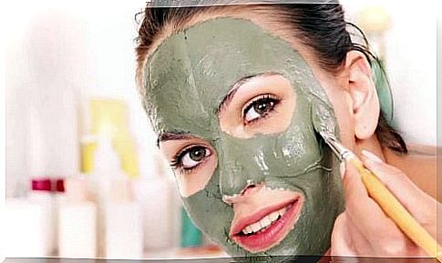 woman applying clay mask