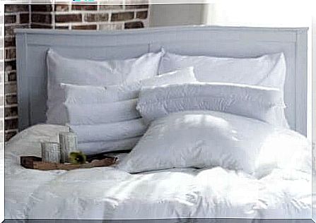 Bed with quilt and white pillows.