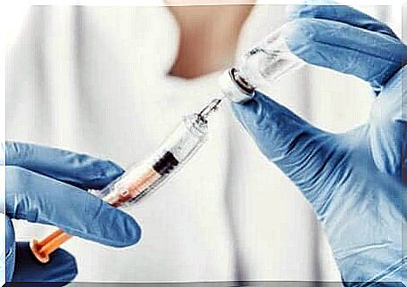 Hand with vaccine and syringe.