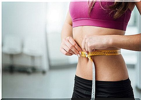 Girl with a flat stomach measures the waist