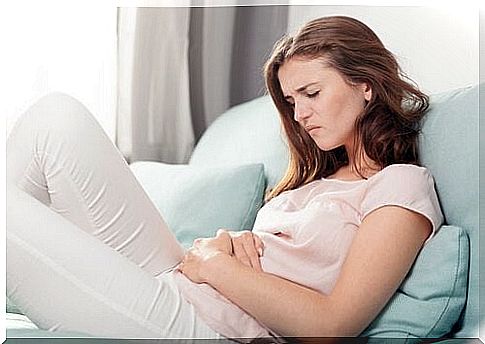 Girl with stomach ache resting on sofa