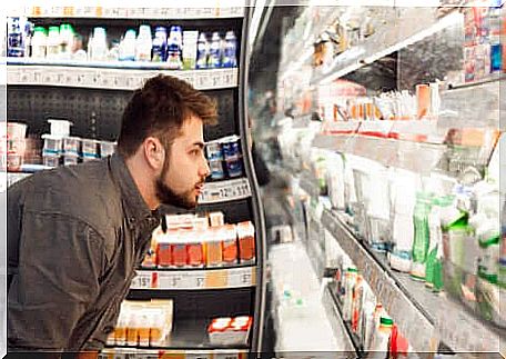 Boy at the supermarket in front of the dairy counter.