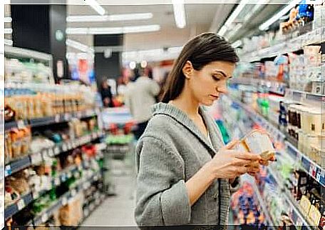 Woman checks the yogurt label for food safety.