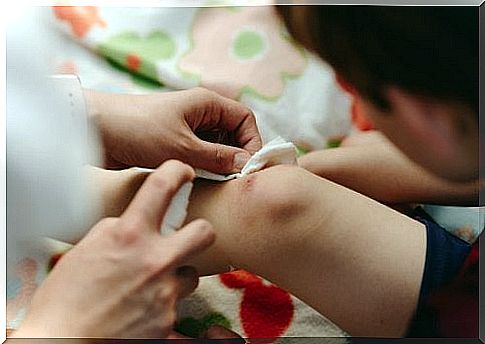 Mom disinfects baby's knee wound