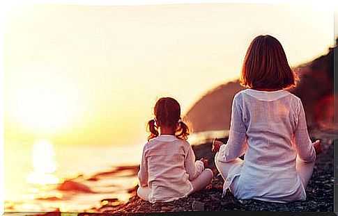 Little girls on the sea practicing yoga